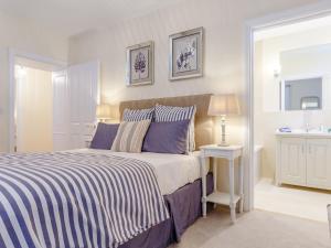 sypialnia z łóżkiem z niebieskimi i białymi paskami w obiekcie 2 Bed in Westward Ho 77590 w mieście Northam