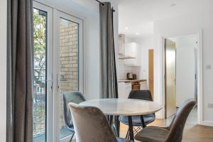 a kitchen and dining room with a table and chairs at Prime Location Flats in London