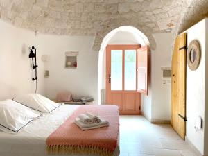 sypialnia z łóżkiem z dwoma ręcznikami w obiekcie Trullo Panna Fragola - Exclusive four bedroom Villa & Private pool w mieście Martina Franca