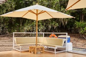 two chairs and an umbrella on a deck at El Manatí - River Experience in Iquitos