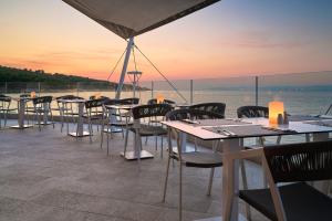a group of tables and chairs on a roof at Grand Hotel View in Postira