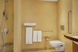 a bathroom with a toilet and a sink with towels at The Westin Warsaw in Warsaw