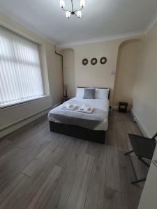 um quarto com uma cama grande e pisos em madeira em House In the heart of valleys em Ebbw Vale