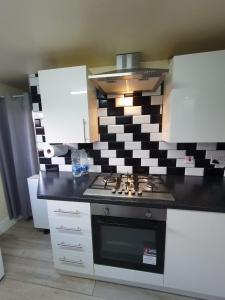 a kitchen with a stove and a geometric wall at House In the heart of valleys in Ebbw Vale