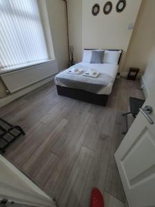 een slaapkamer met een bed en een houten vloer bij House In the heart of valleys in Ebbw Vale