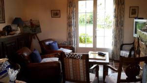 ein Wohnzimmer mit Stühlen, einem Tisch und einem Fenster in der Unterkunft Maison de vacances Sauzon in Sauzon