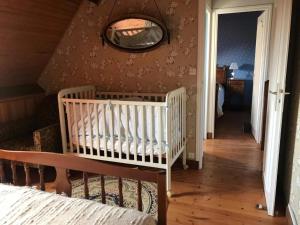 a bedroom with a crib and a mirror on the wall at Maison de vacances Sauzon in Sauzon