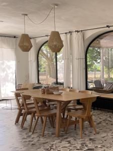 jadalnia z drewnianym stołem i krzesłami w obiekcie Trullo Panna Fragola - Exclusive four bedroom Villa & Private pool w mieście Martina Franca