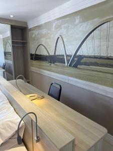 a room with a large painting of a bridge at Flat no Brasília Lider, 14º Andar in Brasilia