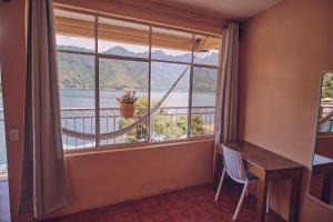 Zimmer mit einem Fenster mit einem Tisch und Aussicht in der Unterkunft Amigos in San Pedro La Laguna