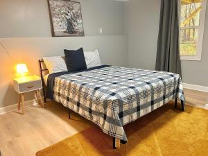 a bedroom with a bed with a checkered blanket at Comfy Lower Lvl Apt with Jetted Tub Near Uptown and UNC in Charlotte