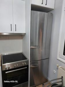een keuken met een roestvrijstalen koelkast en een fornuis bij Το σπίτι της Μαρίας in Chios