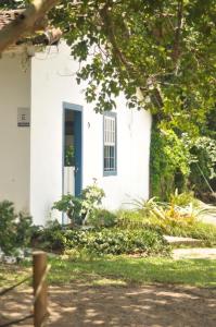 a white house with a blue door at Casinha Pescador in Paraty