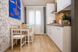 une cuisine avec une table et des chaises dans une pièce dans l'établissement Biennale Comfort House - modernità a Castello, à Venise