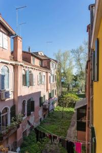 un groupe de bâtiments avec une corde à vêtements entre eux dans l'établissement Biennale Comfort House - modernità a Castello, à Venise