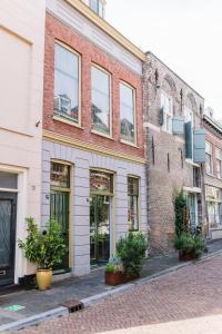 a brick building with windows and plants on a street at B&B À la Lon in Dordrecht