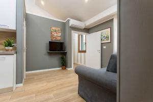 un salon avec un canapé et une télévision dans l'établissement Biennale Comfort House - modernità a Castello, à Venise