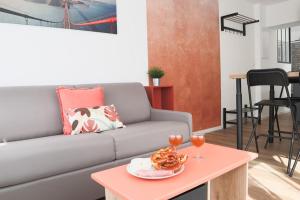 een woonkamer met een bank en een tafel met een bord eten bij {Le Factory}, proche EuroAirport in Saint-Louis