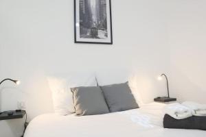 a bedroom with a white bed with two lamps at {Le Factory}, proche EuroAirport in Saint-Louis