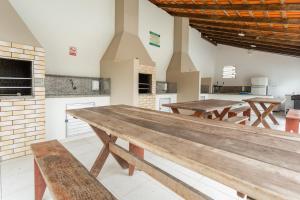 a large room with wooden tables and a kitchen at Ao lado do Shopping e da Beiramar Norte GB1800 in Florianópolis