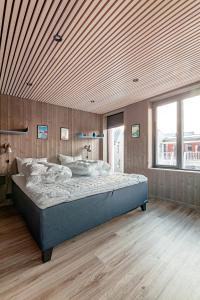 a bedroom with a large bed with a wooden ceiling at Rorbuleilighet 1J Henningsvær in Henningsvær