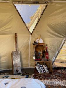 a room with a tent with a book shelf in it at Eagles Dôme in Bou Tferda