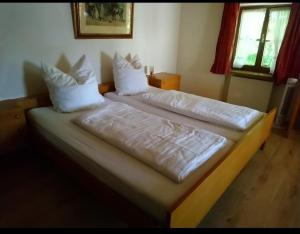 a bedroom with two beds with white sheets and pillows at Gasthof Mühlegger in Wildsteig