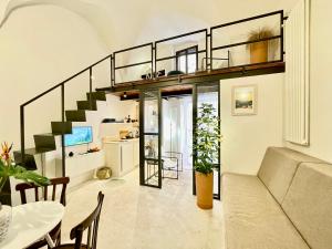 a loft apartment with a staircase and a living room at I Granai - Marea Collection in Nardò