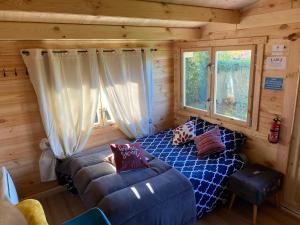 a bedroom with a bed and a couch in a cabin at Caravane Ruby 