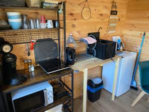 a kitchen with a desk with a laptop and a microwave at Caravane Ruby 