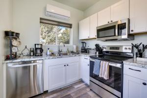 a kitchen with white cabinets and a stove top oven at Cedar City Apartment about 3 Mi to Downtown! in Cedar City