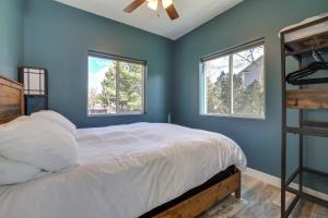 a blue bedroom with a bed and two windows at Cedar City Apartment about 3 Mi to Downtown! in Cedar City