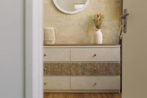 a bathroom with a white dresser and a mirror at By Homy in Bordeaux
