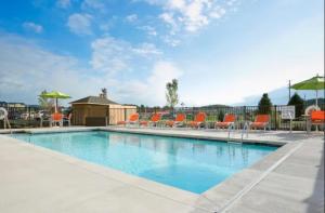 Clinton的住宿－Hampton Inn Knoxville Clinton I-75，一座带橙色椅子和遮阳伞的大型游泳池
