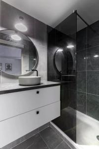 a bathroom with a shower with a sink and a mirror at Chapelle/Ordener : Magnifique appartement 1BR/4P in Paris