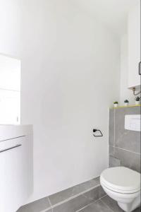 a white bathroom with a toilet and a sink at Chapelle/Ordener : Magnifique appartement 1BR/4P in Paris