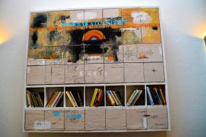 a book shelf with a painting on the wall at Bab Atlantique in Essaouira