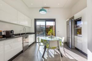 a kitchen with a table and chairs in a room at Villa Dalia, Personnels et option piscine in Marrakesh