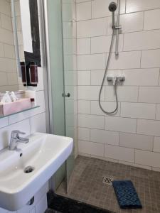 ein Bad mit einem Waschbecken und einer Dusche in der Unterkunft Berghotel-Willingen in Willingen