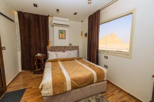 a bedroom with a bed with a view of the pyramids at White Pyramids inn in Cairo +75 photos