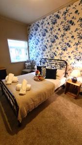 a bedroom with a bed with a floral wallpaper at Potter's Place at Newcastle under Lyme, Close to Keele University in Longport