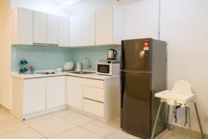 a kitchen with a black refrigerator and white cabinets at Deluxe Studio/Gurney/Mansion One in George Town