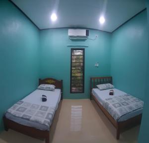 Duas camas num quarto com tecto azul em Beijing View Homestay em Rantau Panjang
