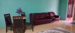uma sala de estar com um sofá e uma mesa em Beijing View Homestay em Rantau Panjang