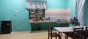 a dining room with a table and chairs and a counter at Beijing View Homestay in Rantau Panjang