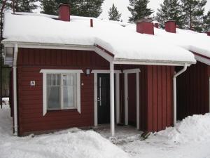 a red house with snow on top of it at Koli Country Club in Hattusaari