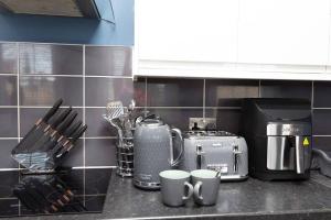 eine Küchentheke mit zwei Kaffeetassen drauf in der Unterkunft Lavish 2Bed Apartment in the Heart of Birkenhead in Birkenhead