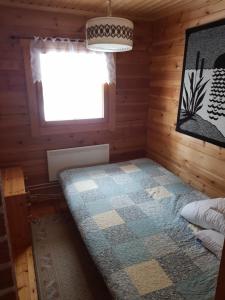 Cette chambre comprend un lit dans une cabane en rondins. dans l'établissement Villa Vaskela, à Virrat