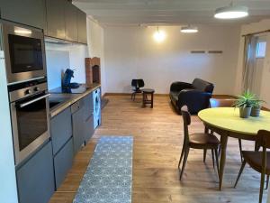 a kitchen and living room with a table and chairs at La maisonnette de Naomi in Coutances +2 photos