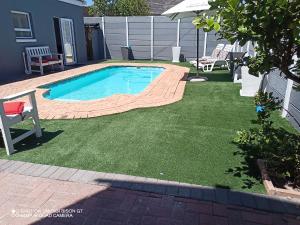 una pequeña piscina en un patio con césped en Palm Tree en Ciudad del Cabo